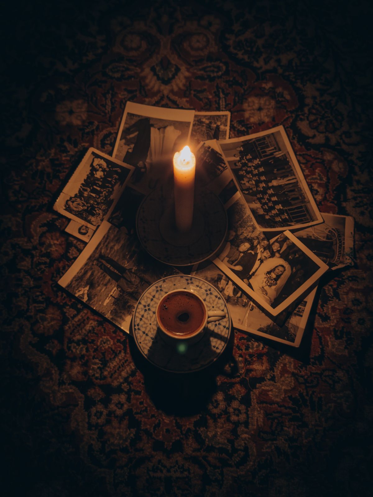 Vela encendida junto a fotografías antiguas familiares, ritual de sanación ancestral