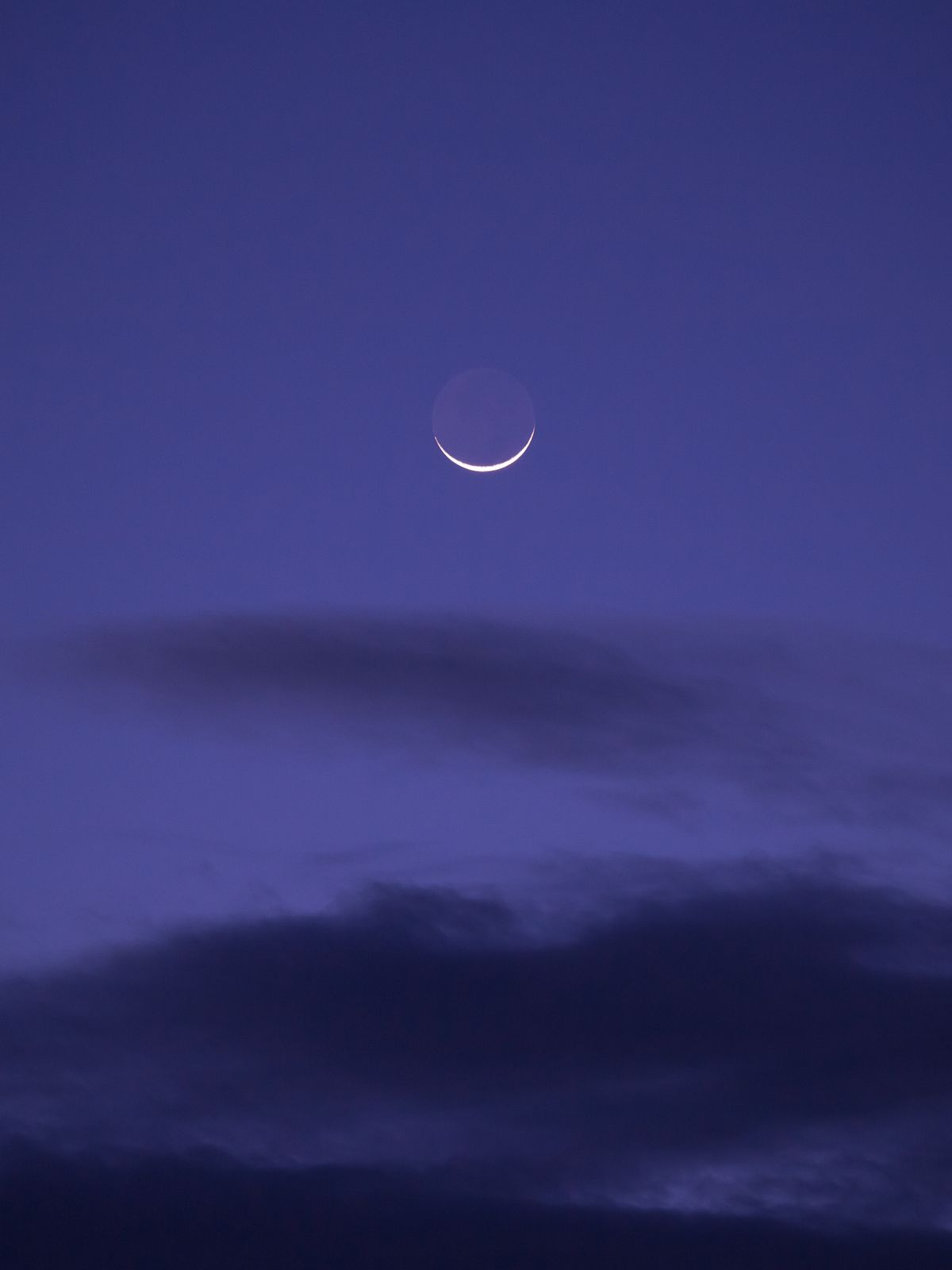 Luna creciente en cielo púrpura de atardecer, ritual de luna nueva