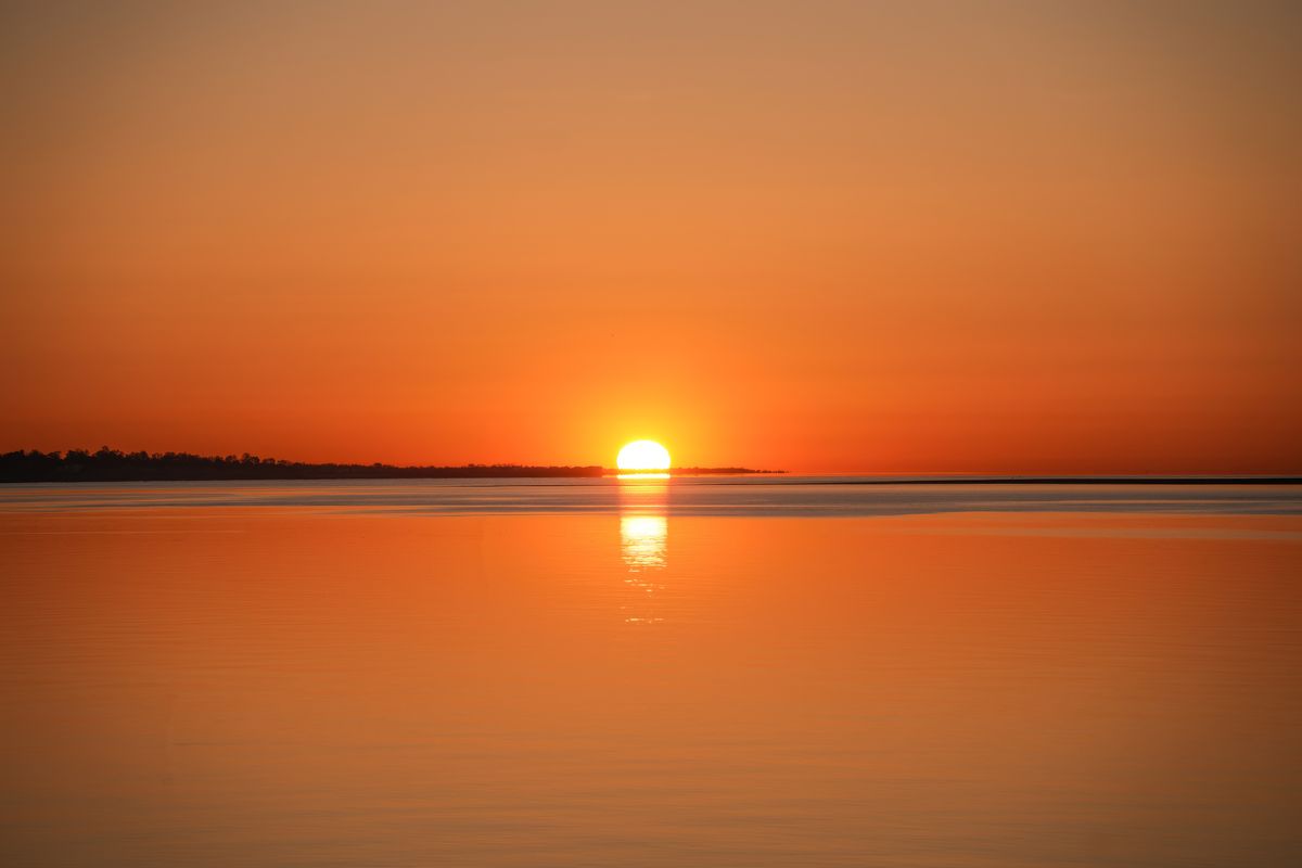 Atardecer dorado sobre el mar en calma, ritual de solsticio
